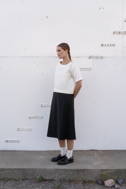 Model wearing ivory silk top and black wool skirt.