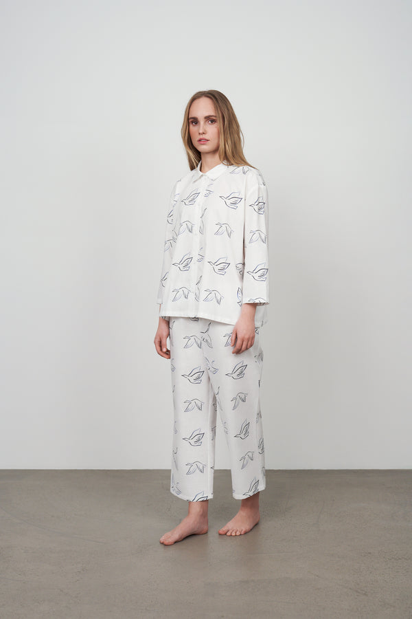 Archetype women's white pyjama set with painted blue swans bird pattern.